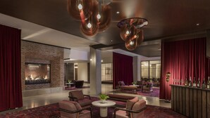 Eine moderne Lobby mit Kamin, Sitzecke und Bar.