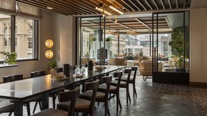A modern dining area with a long table, chairs, and pendant lighting. - Thompson Denver, by Hyatt (Denver)
