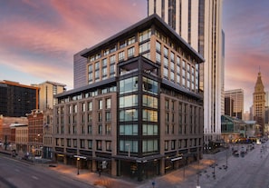 A modern hotel with a prominent corner location, large windows, and a flat roof design.
