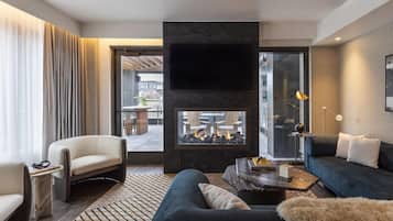 Un salon moderne avec une cheminée, un canapé, un fauteuil et une table basse.