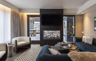 Una sala de estar moderna con chimenea, un sofá, un sillón y una mesa de centro.