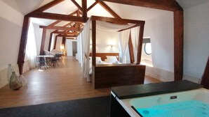 A spa room with a wooden ceiling, a massage bed, a massage table, and a hot tub. - Très Grand Loft Sous Les Toits - Château La Vidalle (Vendres)