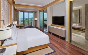 A hotel room with a bed, a TV, a balcony with a view, and a desk with a lamp. - Hualuxe Suzhou Bay Hot Spring Resort, an IHG Hotel (Suzhou)