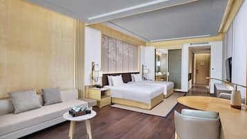 A modern hotel room with a large bed, a sofa, a dining table, and a TV.
