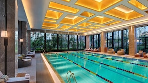 A swimming pool with a sunken seating area, large windows, and a modern ceiling design. - Hualuxe Suzhou Bay Hot Spring Resort, an IHG Hotel (Suzhou)