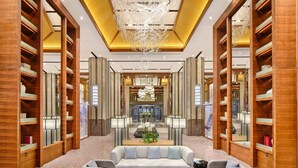 A modern hotel lobby with a central seating area, wooden bookshelves, and a chandelier. - Hualuxe Suzhou Bay Hot Spring Resort, an IHG Hotel (Suzhou)