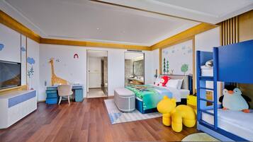 A child's bedroom with a bunk bed, desk, chair, and playful wall decorations.