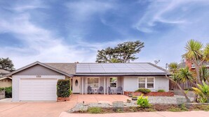 A single-story house with a garage, a covered patio with chairs, and a solar panel roof. - 3828 The 9th Green - Near Golf Links & Bay Trail (Pacific Grove)