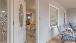 A covered patio area with a dining table and chairs, a door with decorative glass panels, and a view into the house. - 3828 The 9th Green - Near Golf Links & Bay Trail (Pacific Grove)