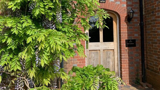 A brick building with a wooden door and a window. - The Estate - 11 Bed - Sleeps 22 - Private Garden (Hailsham)