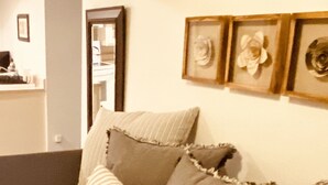 Une chambre à coucher avec une couvre-lit à motifs, un plaid rayé et trois coussins.