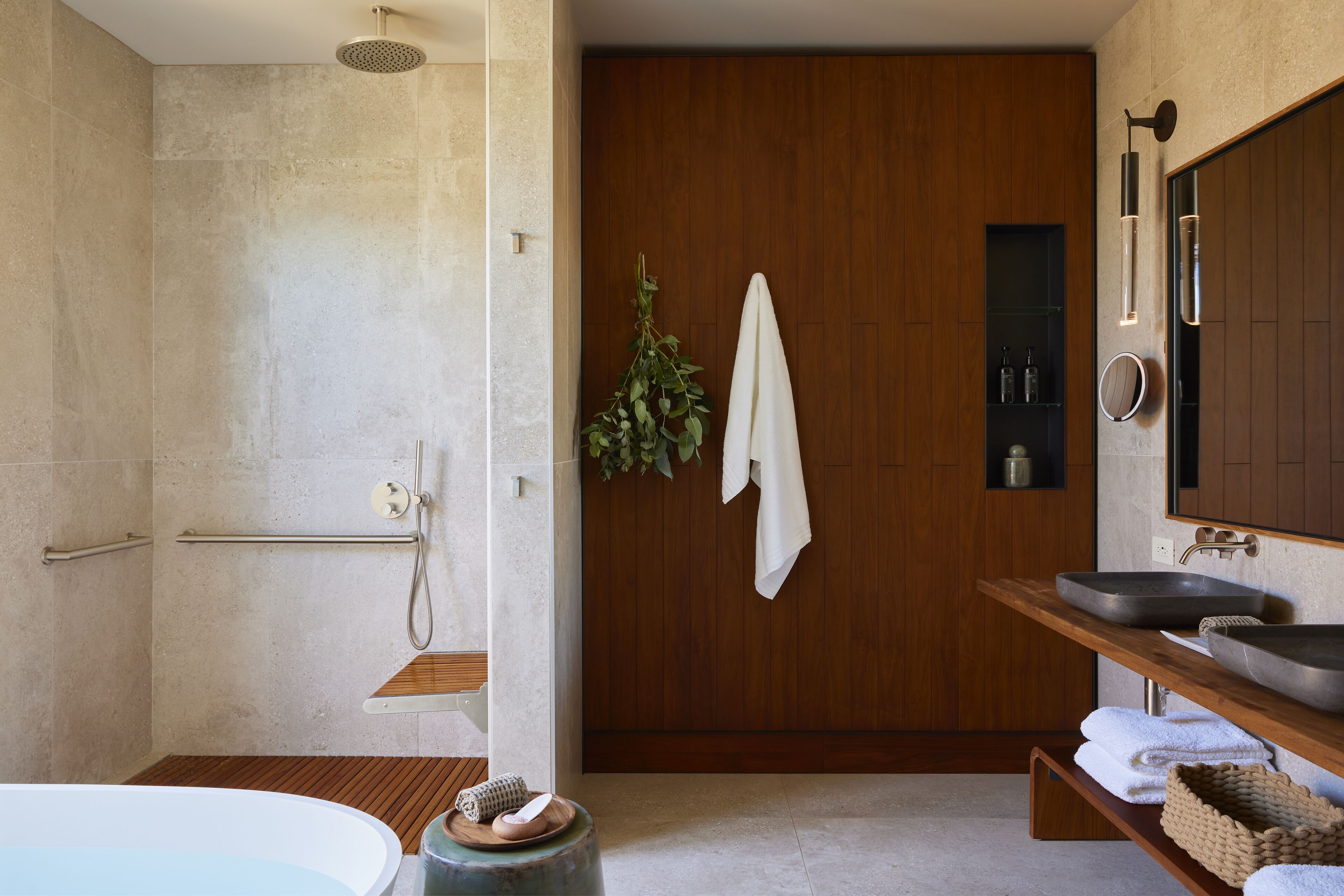 A modern bathroom with a shower, a bathtub, a wooden vanity with a sink, and a mirror.