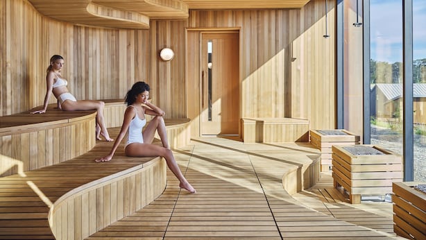 A sauna with wooden benches and a large window. - Stanly Ranch, Auberge Collection (Napa)