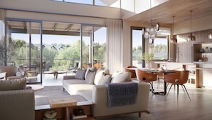 A spacious living area with a large sliding glass door leading to a balcony, a cozy seating area with a sofa and chairs, and a modern kitchen with pendant lighting. - Stanly Ranch, Auberge Collection (Napa)