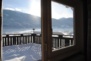 Una habitación con vistas a montañas nevadas y un lago.