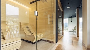 Een moderne hotel lobby met een glazen wand, een houten bank en uitzicht op de stad.