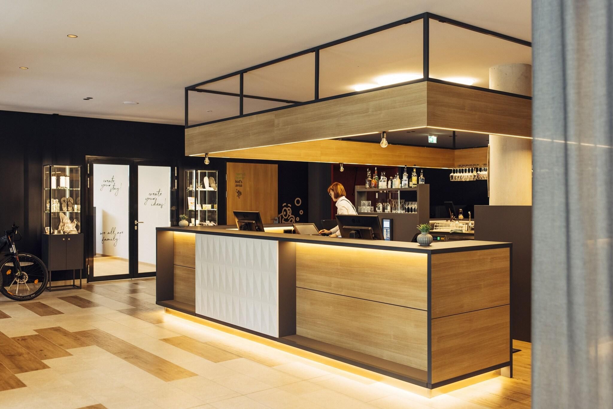 A modern reception area with a wooden counter, a bike in the background, and a glass display case.