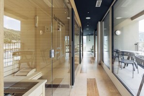 Un spa moderno con paredes de vidrio, suelo de madera y vistas a un lago.