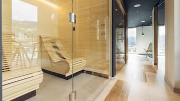 A modern hotel lobby with a glass partition, a wooden bench, and a view of the city.