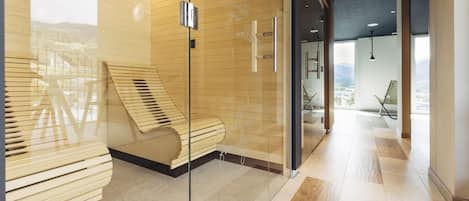 A modern hotel lobby with a glass partition, a wooden bench, and a view of the city.
