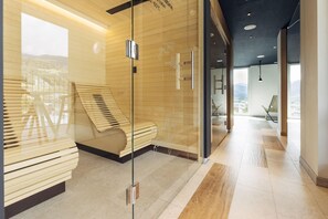 Un moderno vestíbulo de hotel con un separador de vidrio, un banco de madera y vistas a la ciudad.
