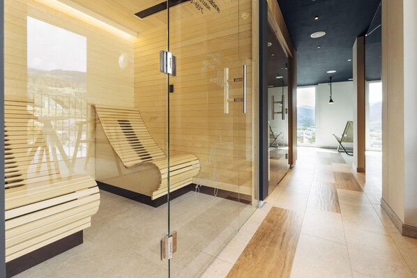 Un moderno vestíbulo de hotel con un separador de vidrio, un banco de madera y vistas a la ciudad.