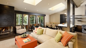 A modern living room with a fireplace, sofa, and dining area. - Deluxe 2 Bedroom Apartments at Resort with Outdoor Pool & Hot Tub (Aspen)
