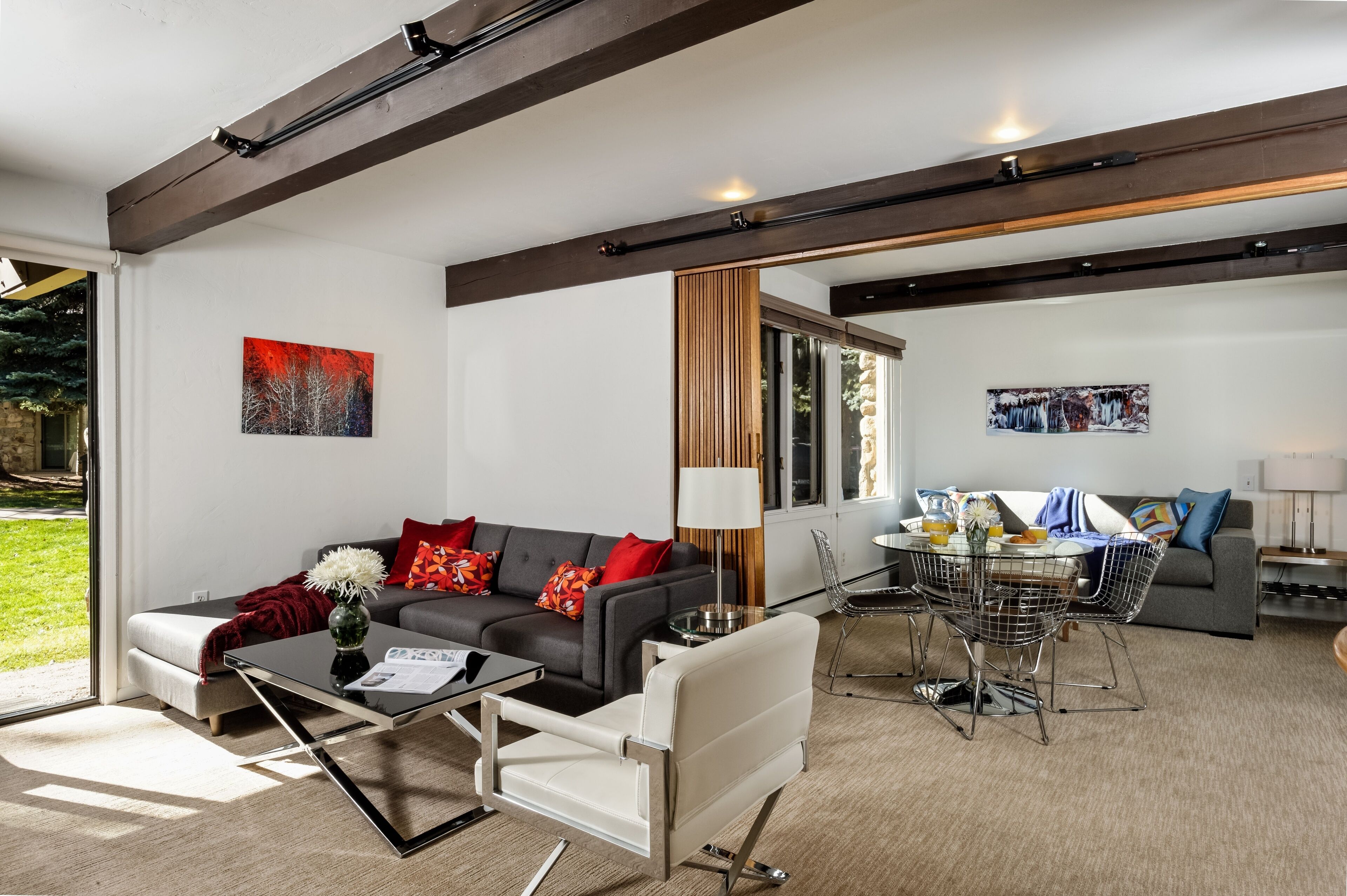 A modern living room with a sofa, coffee table, and dining area.