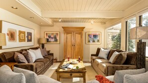 A cozy living room with two sofas, a coffee table, and artwork on the walls. - Comfortable & Modern 2 Bedroom Apartments - Right on the Slopes! (Aspen)