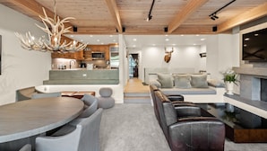 A modern interior with a dining area, seating, a kitchen, and a living space. - Deluxe 3 & 4 Bedroom Aspen Apartments Next to Silver Queen Gondola (Aspen)