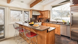 A modern kitchen with a large island, wooden cabinets, stainless steel appliances, and a view of a snowy landscape. - Deluxe 3 & 4 Bedroom Aspen Apartments Next to Silver Queen Gondola (Aspen)