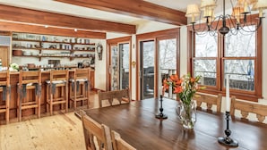 A wooden dining area with a large table, chairs, and a chandelier. - Deluxe 3 & 4 Bedroom Aspen Apartments Next to Silver Queen Gondola (Aspen)
