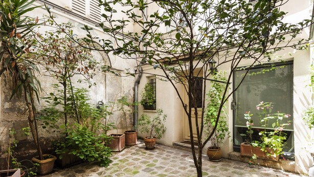 A courtyard with potted plants and a tiled floor. - My Nest Inn Marais - 5 pers- 53m² - Heart of Paris (Paris)