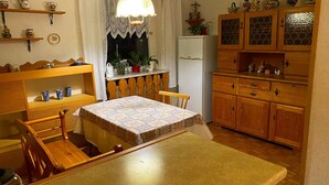 Una cocina acogedora con armarios de madera, una mesa de comedor y una lámpara colgante.