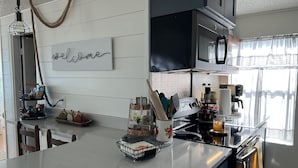 Une cuisine moderne dotée d’un îlot central, d’un panneau d’accueil et de divers appareils de cuisine.