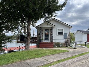 A house with a front porch, a small deck, and a view of a lake. - Vintage Lake Front Cottage, thoughtful updates, cleaned and cared for by owner (Hot Springs)