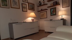 Una camera da letto con un letto, due comodini con lampade, una cassettiera e opere d'arte alle pareti.