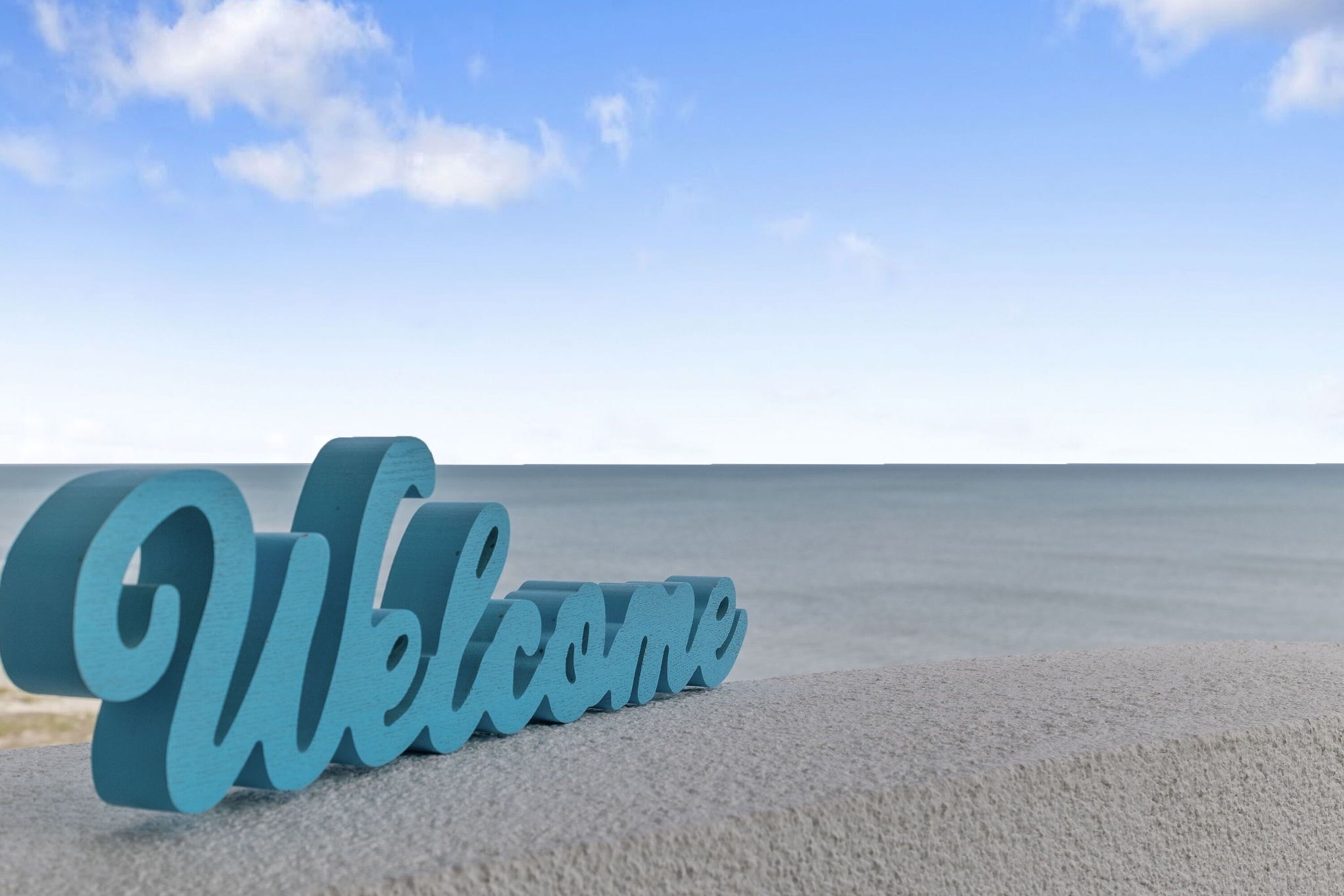 A 'Welcome' sign on a beach.
