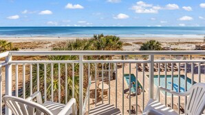 A balcony with white chairs, a pool, and a view of the beach and ocean. - Stunning Oceanfront View Atlantica Tower (Myrtle Beach)