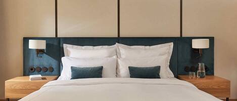 A hotel room with a bed, two bedside tables, and a headboard.