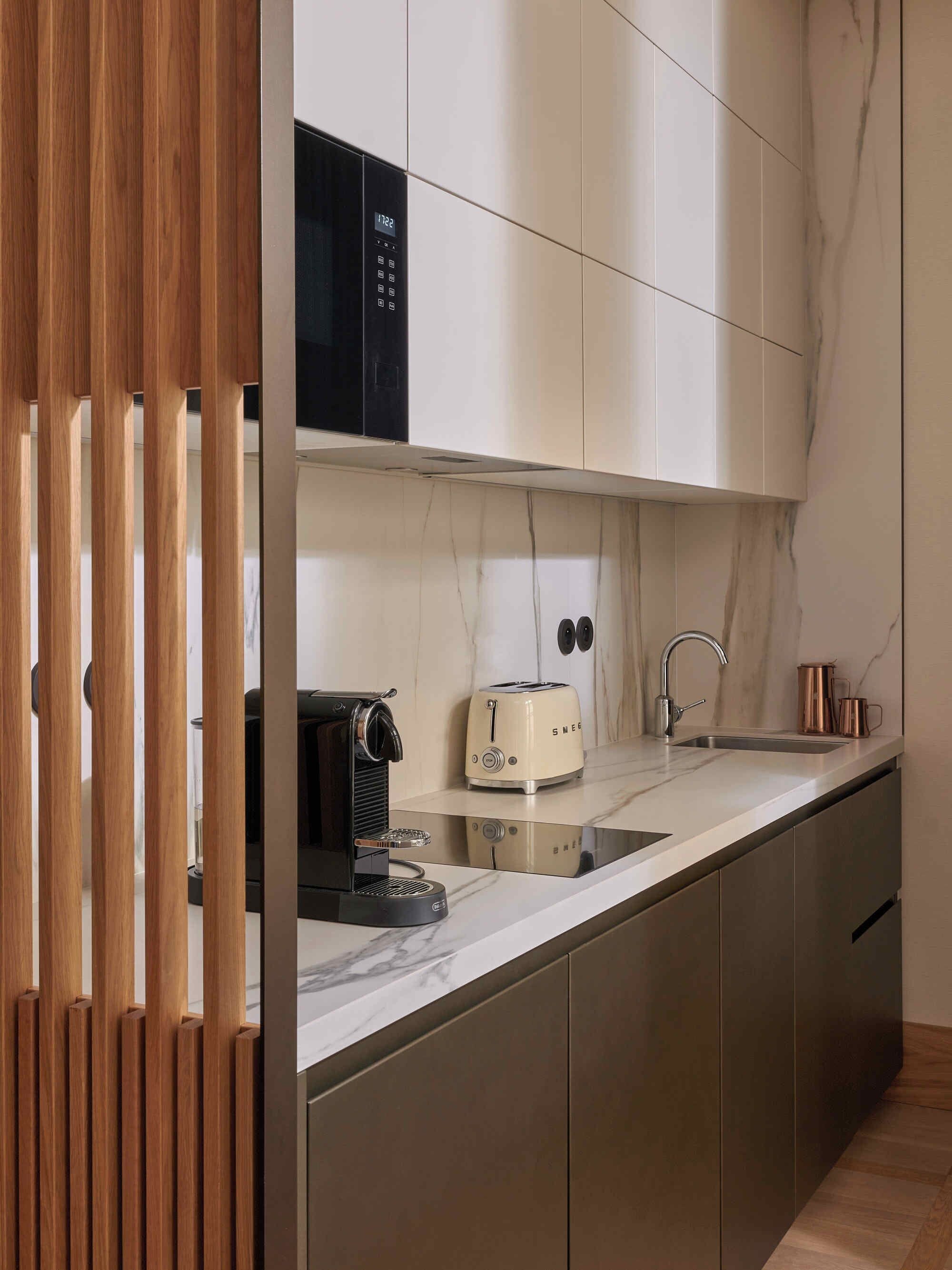 A modern kitchen with a built-in microwave, a toaster, and a sink.