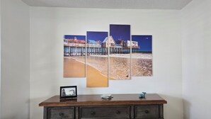 Un mur orné d’une œuvre d’art composée de plusieurs panneaux et représentant une scène de plage.