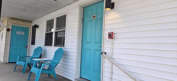 A building with two turquoise doors, one labeled "REC ROOM LAUNDRY" and the other marked "1004".