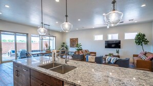 A spacious kitchen with granite countertops, a large island, and modern pendant lighting. - Arcadia 50 | Shuffleboard * Sleeps 22 * Views of Red Rocks (Santa Clara)