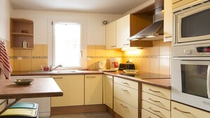 A compact kitchen with a sink, stove, and microwave. There is a window providing natural light and a shelf with kitchen items. - Feet of Chantemerle's ski slopes - 6 people (Chantemerle)