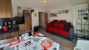 A compact living space with a kitchenette, a dining area, and a seating area with a sofa and a table. - Studio + Mountain corner - 4/6 people - 250m from the ski slopes (Chantemerle)