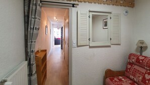 A hallway with a wooden bench, a radiator, and a red patterned sofa. - Studio + Mountain corner - 4/6 people - 250m from the ski slopes (Chantemerle)