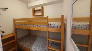 A bunk bed with a wooden frame, a small shelf, and a mirror on the wall. - Studio + Mountain corner - 4/6 people - 250m from the ski slopes (Chantemerle)