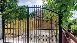 A metal gate with decorative patterns, a bamboo fence, and a red railing. - Stunning Home in Herceg Novi With 1 Bedrooms and Wifi (Baosici)