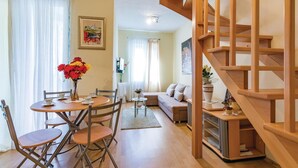 A cozy living room with a dining area, a staircase, and a view of the living room through a glass door. - Awesome Home in Rovinj With Wifi and 0 Bedrooms (Rovinj)